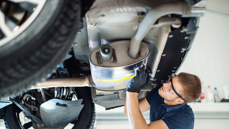 A mechanic working on a car's exhaust