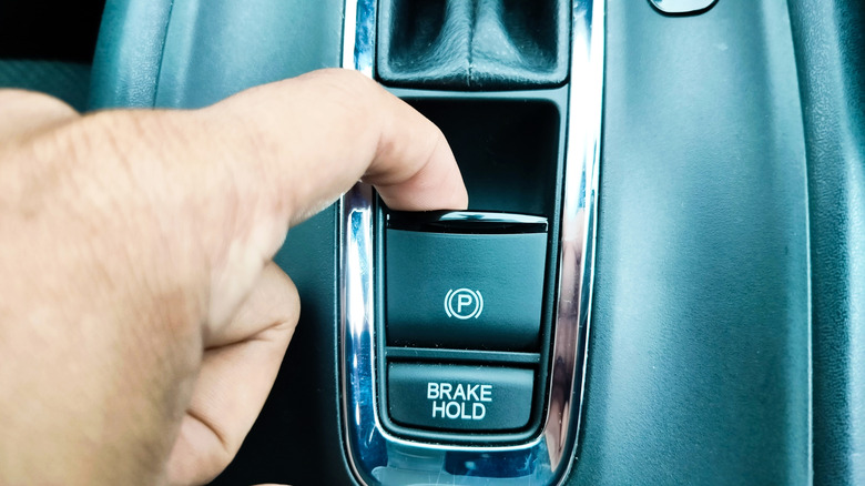 Finger activating a car's electronic parking brake