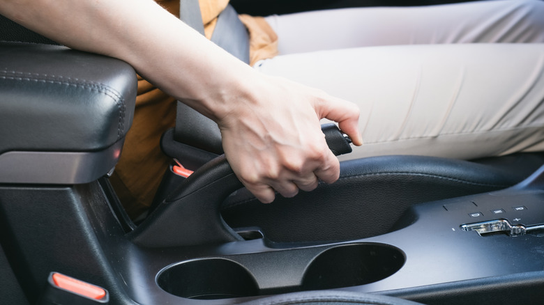 Driver pulls the handbrake on a car