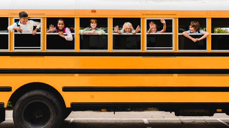 Front view of schoolchildren looking out of the school bus