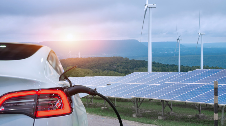 Electric vehicle with solar panels in the background 