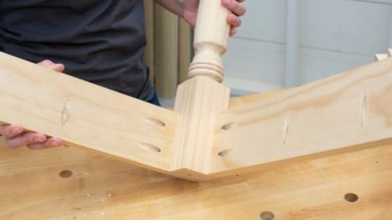 Carpenter showcasing pocket joints hidden inside table