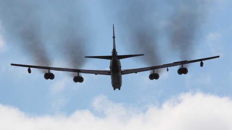 A B-52 bomber with smoke coming out of its engines
