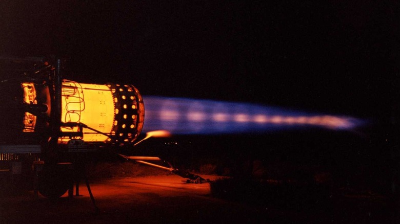A statically mounted Pratt & Whitney J58 jet engine with afterburners running showing shock diamonds against a dark background