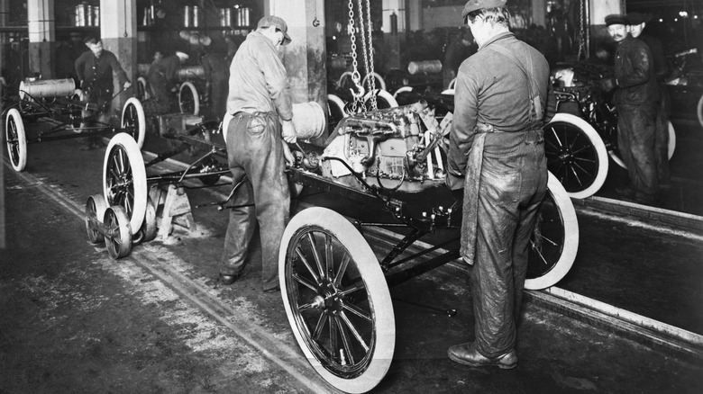 Workers building a Model T on a Ford production line