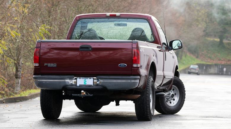 Rear view of a Ford F-250 Super Duty pickup truck with a beautiful forest background
