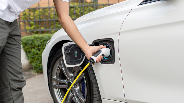 A person plugging a charger into their EV