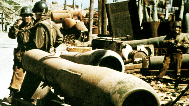 Allied soldiers inspecting Argus 104 pulsejets in a demolished factory during World War II.
