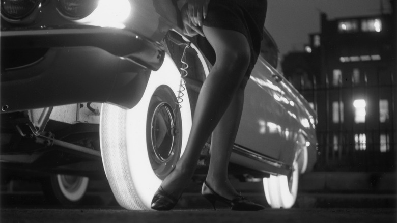 Woman adjusts stockings with help from illuminated tires