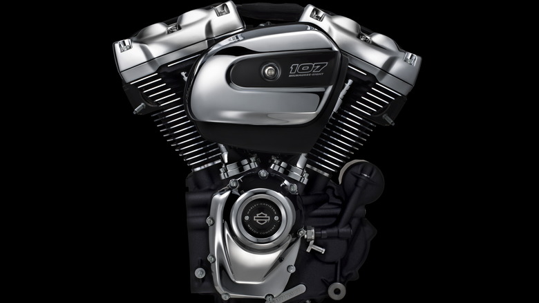 A black and chrome Milwaukee-Eight 107 engine with a black background