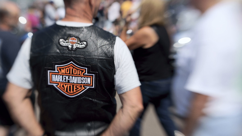 A man in a black leather biker vest with Harley-Davidson rockers
