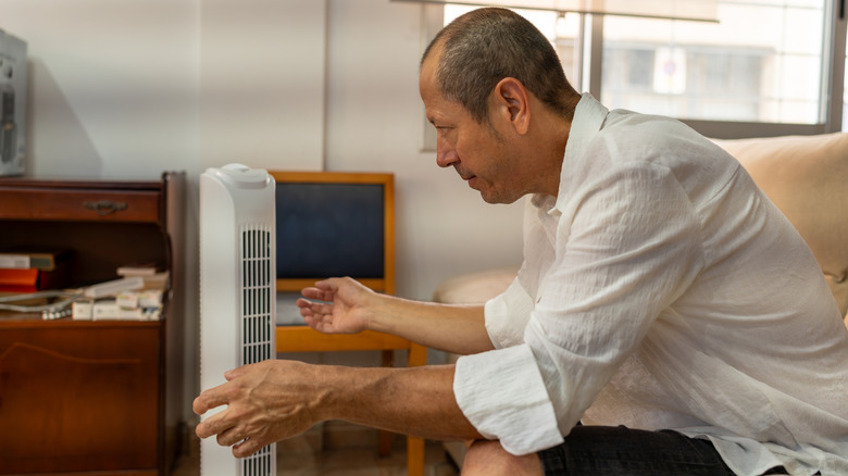 Relaxed male feeling relief from portable air conditione