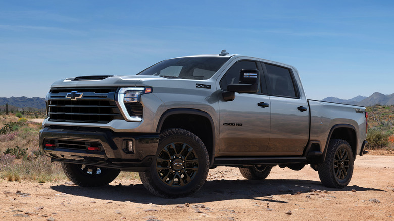 Front 3/4 view of Chevrolet Silverado 2500 HD pickup truck parked in mountainous desert setting