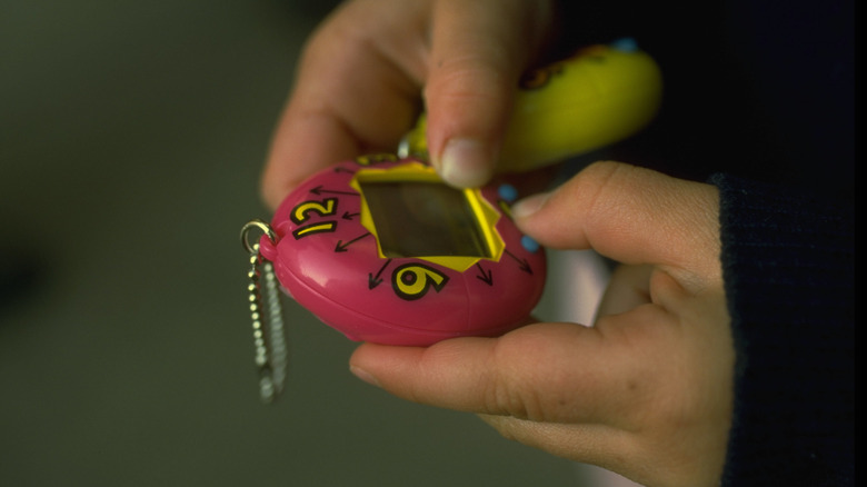 tamagotchi playing hands digital pet
