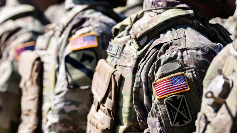 U.S. Army Soldiers standing in formation in uniform with American flag patches