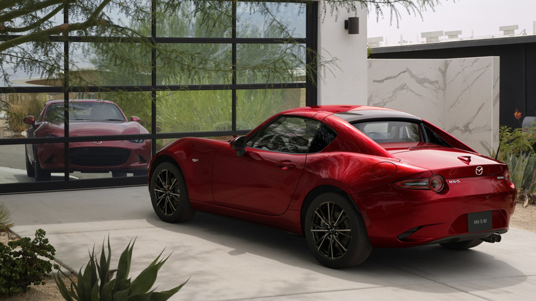 Rear 3/4 view of red 2024 Mazda Miata ND in garage