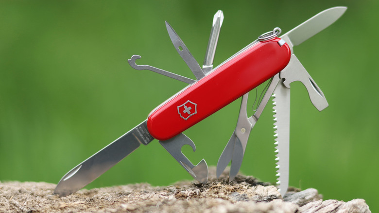 Unsheated swiss army knife stuck inside wood
