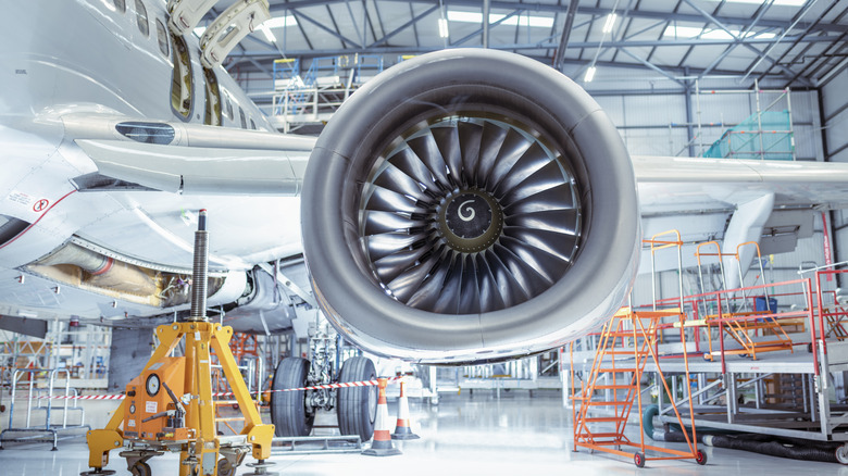 A large jet engine with spiral design in maintenance hanger