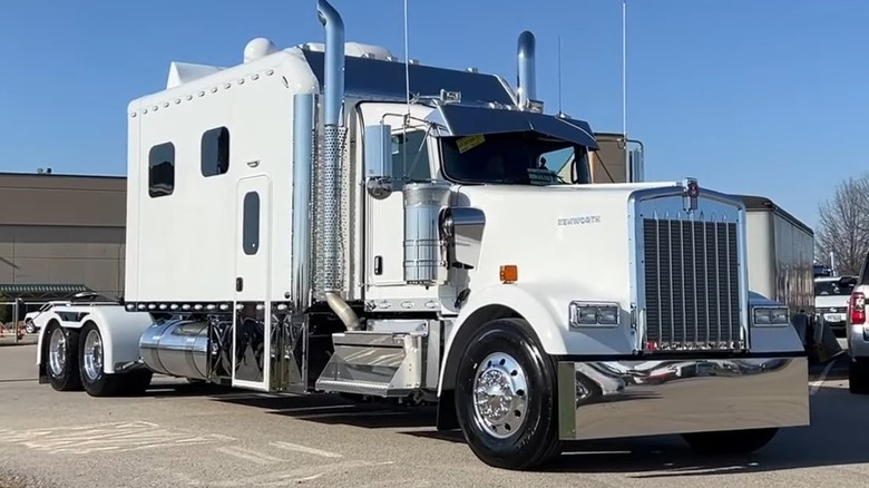 A white Kenworth W900 in a parking lot