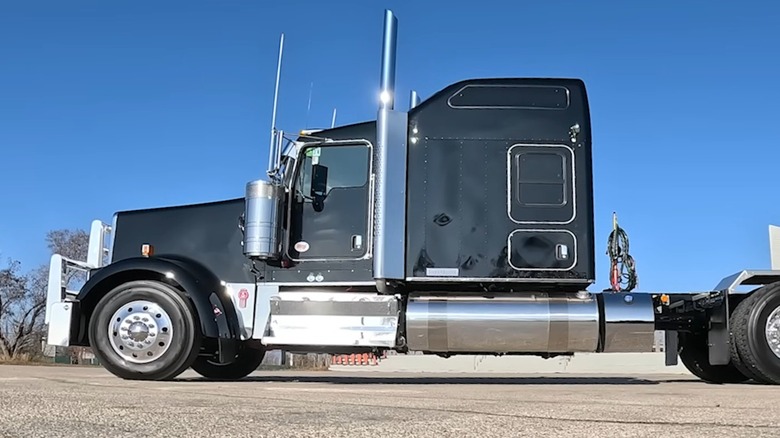 A black Kenworth W900L parked outdoors