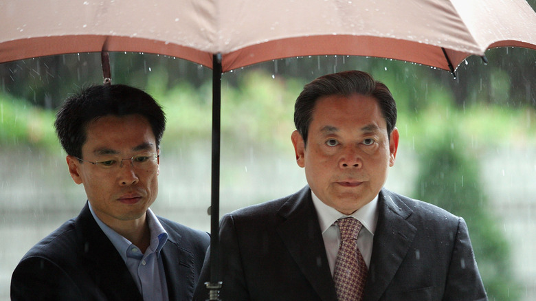 Lee Kun Hee under umbrella rain