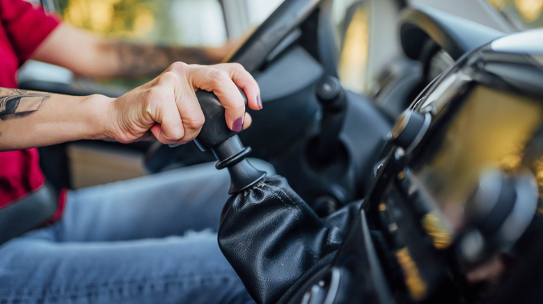 Close-up of a woman's hand shifting gears with a manual transmission