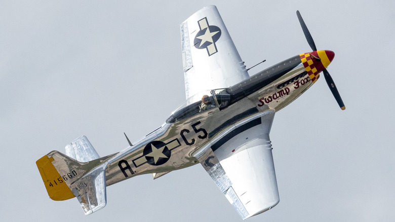 A P-51 Mustang flying over grey cloudy skies