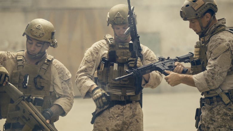 Three US Marines preparing their weapons