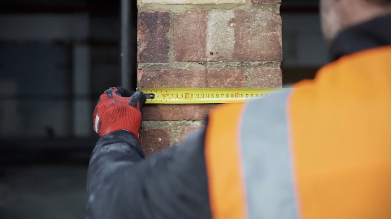 Milwaukee tape measure being used on brick