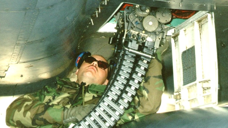 A U.S. servicemember working on the linear linkless ammunition handling system on an aircraft