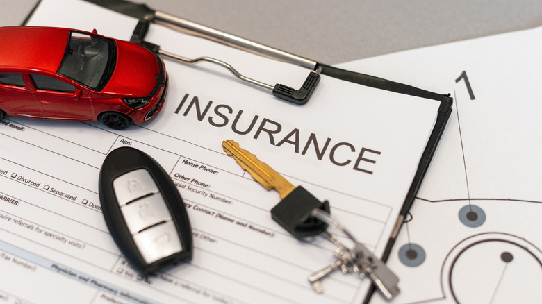Miniature car toys on top of an insurance form
