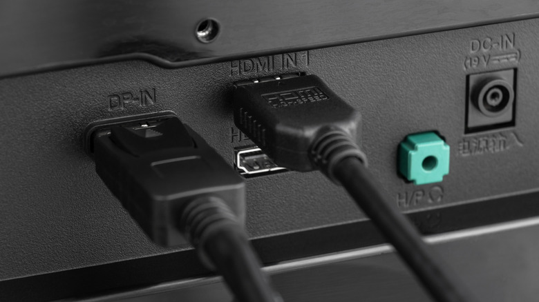 Rear panel of a TV showing cables connected to DisplayPort and HDMI ports