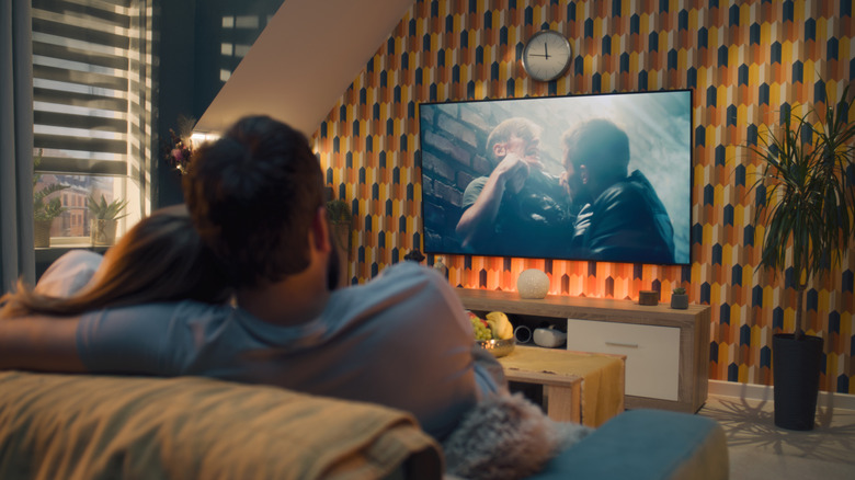 A couple watching TV in a colorful living room