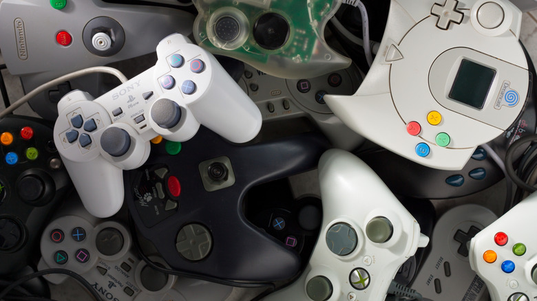 A pile of gamepads from Sony, Sega, Nintendo, Microsoft, Thrustmaster, db Boeder, Vision, Mad Catz, Power Tech