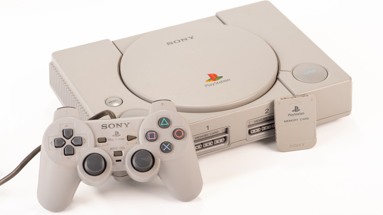 Original PlayStation and controller on white background