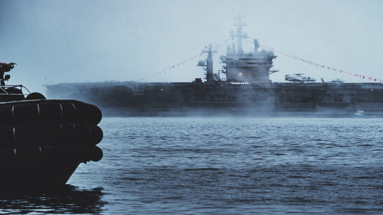 Aircraft carrier close to shore on a stormy day