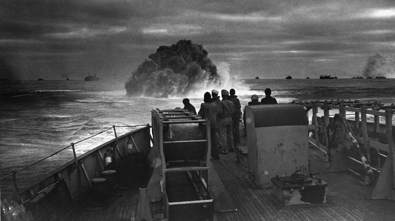 Vessel watches an explosion on the water's surface.
