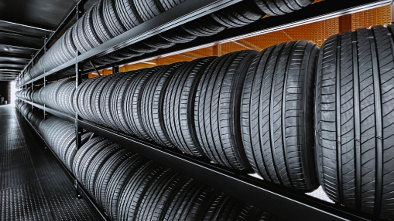 a long row of new car tires on a shelf