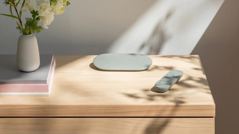 The Google TV Streamer and remote posed on dresser