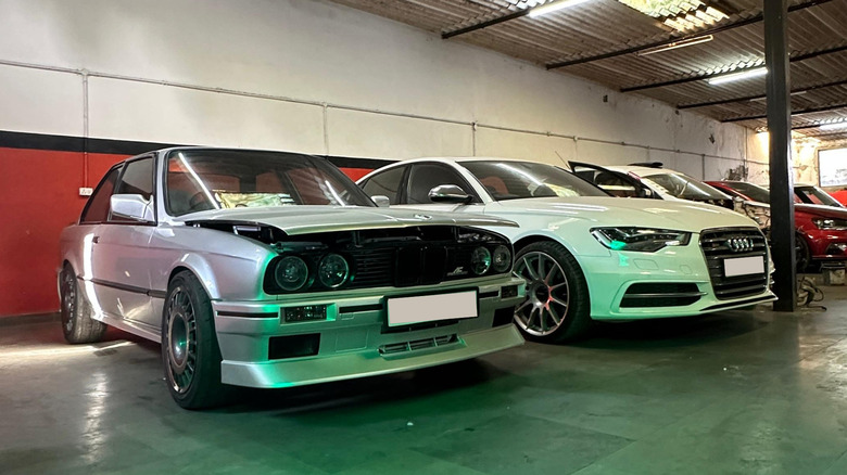 Silver coloured E30 BMW 3-Series and white colored Audi S6.