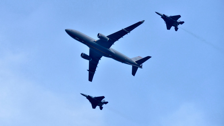 A passenger plane being escorted by 2 fighters flying in the sky as part of Singapore National Day Parade (NDP) rehearsals.