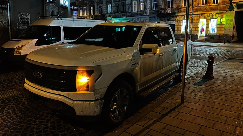A white Ford truck parked on the streets during evening.