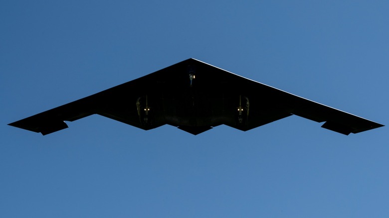 A B-2 Spirit as seen from below against the backdrop of a blue sky