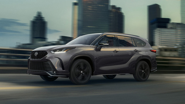 Gray 2026 Toyota Highlander driving in an urban environment.