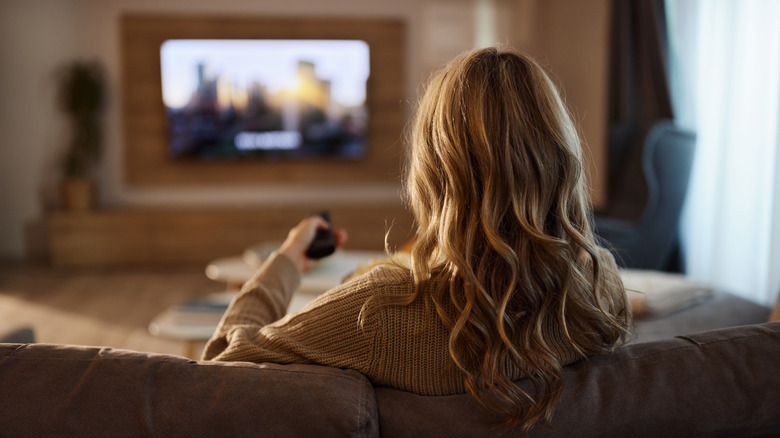Woman controlling a TV using a remote