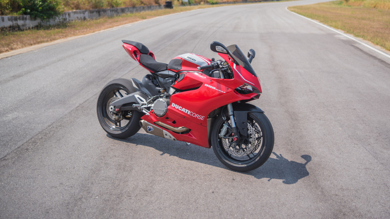 A Ducati Panigale 899 in red parked on a twisty road, front 3/4 view