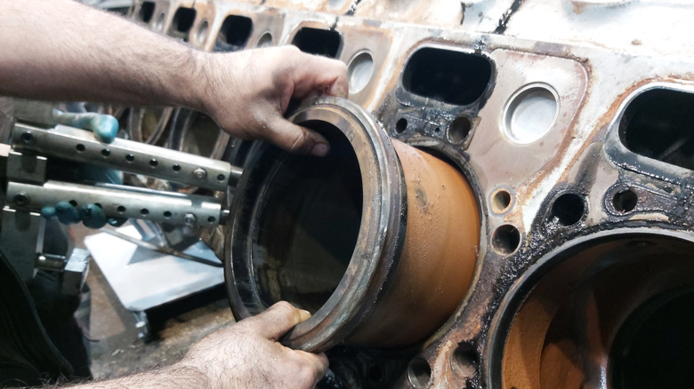 Mechanic replacing industrial engine's cylinder liner