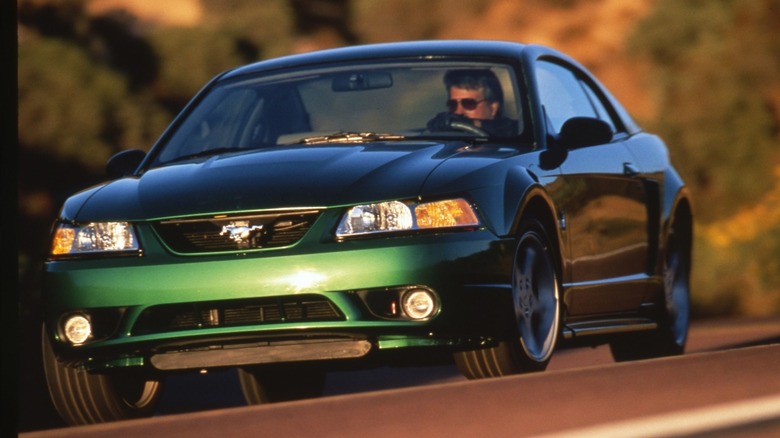 Front 3/4 view of 1999 Mustang Cobra SVT with independent rear suspension cornering hard on curving road