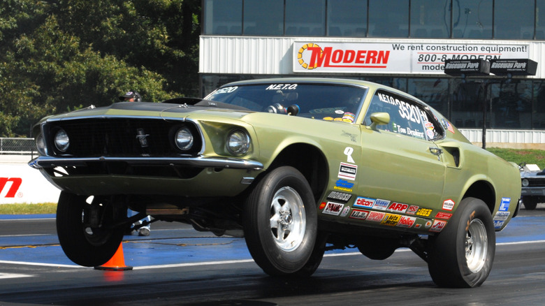 Front 3/4 version Ford Mustang doing a wheelie at the drag strip