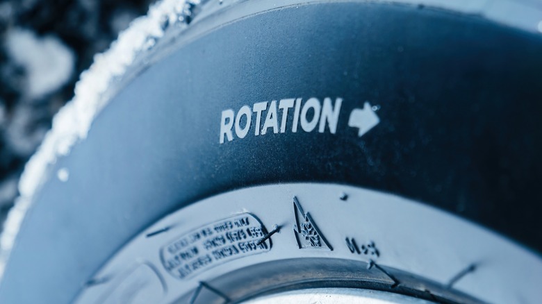 A directional car tire with the rotation direction written on the side wall